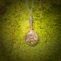 Decorative pendant with a circular design on a green moss background