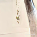 Necklace with a pendant featuring two small shells on a light background