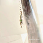 Pendant with a small plant inside, hanging against a neutral background