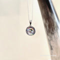 Silver necklace with a colorful pendant on a light background