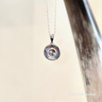 Silver necklace with a colorful pendant on a light background