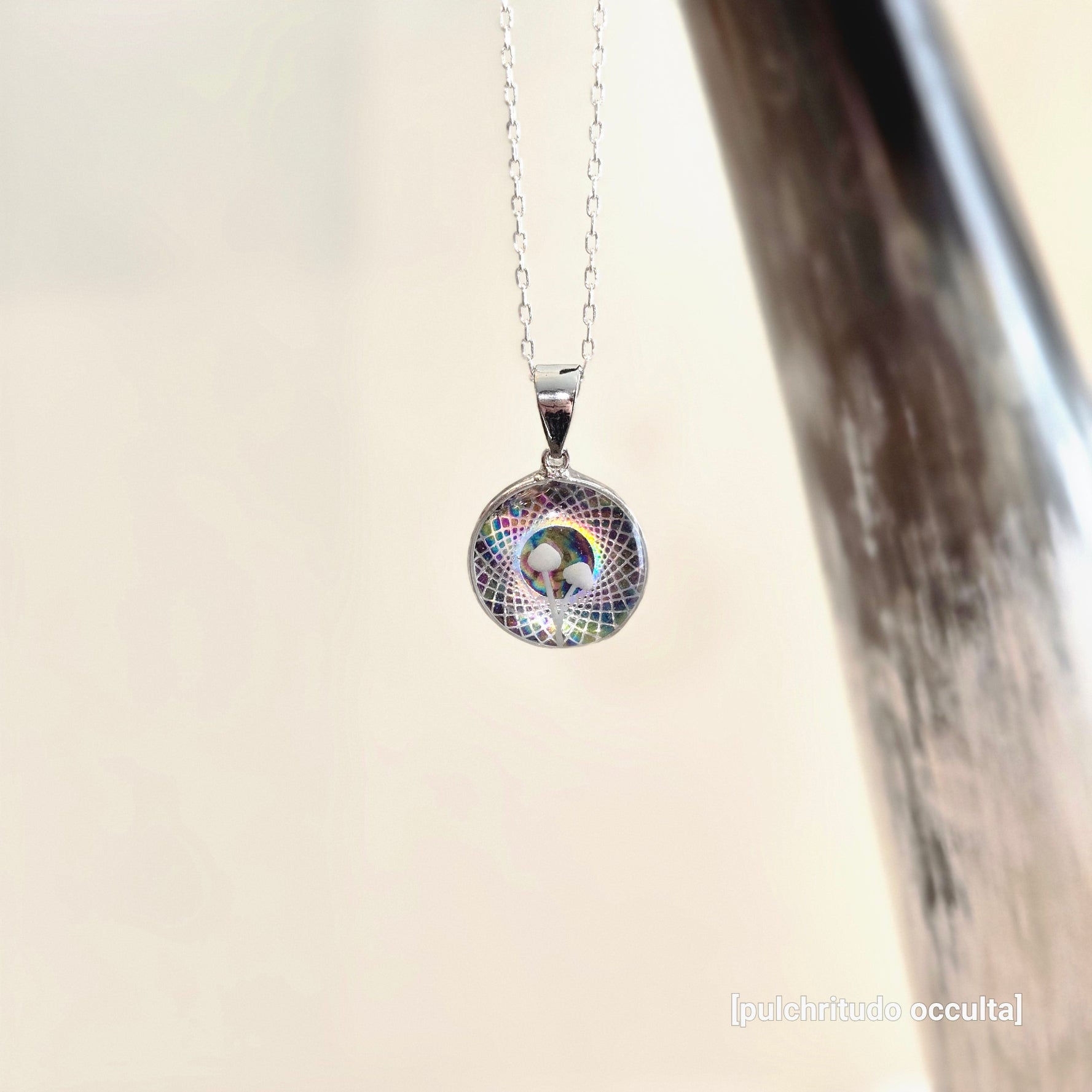 Silver necklace with a colorful pendant on a light background
