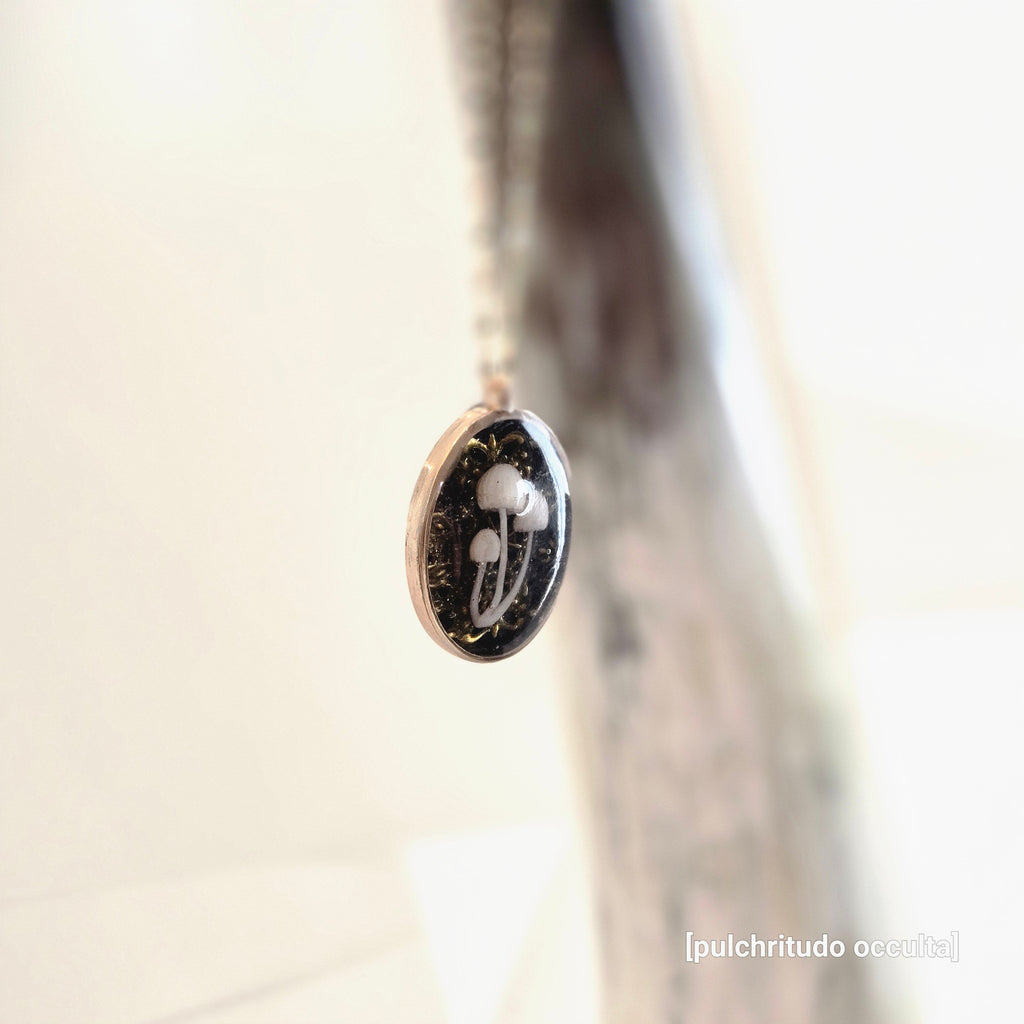 Jewelry pendant with a mushroom design on a blurred background