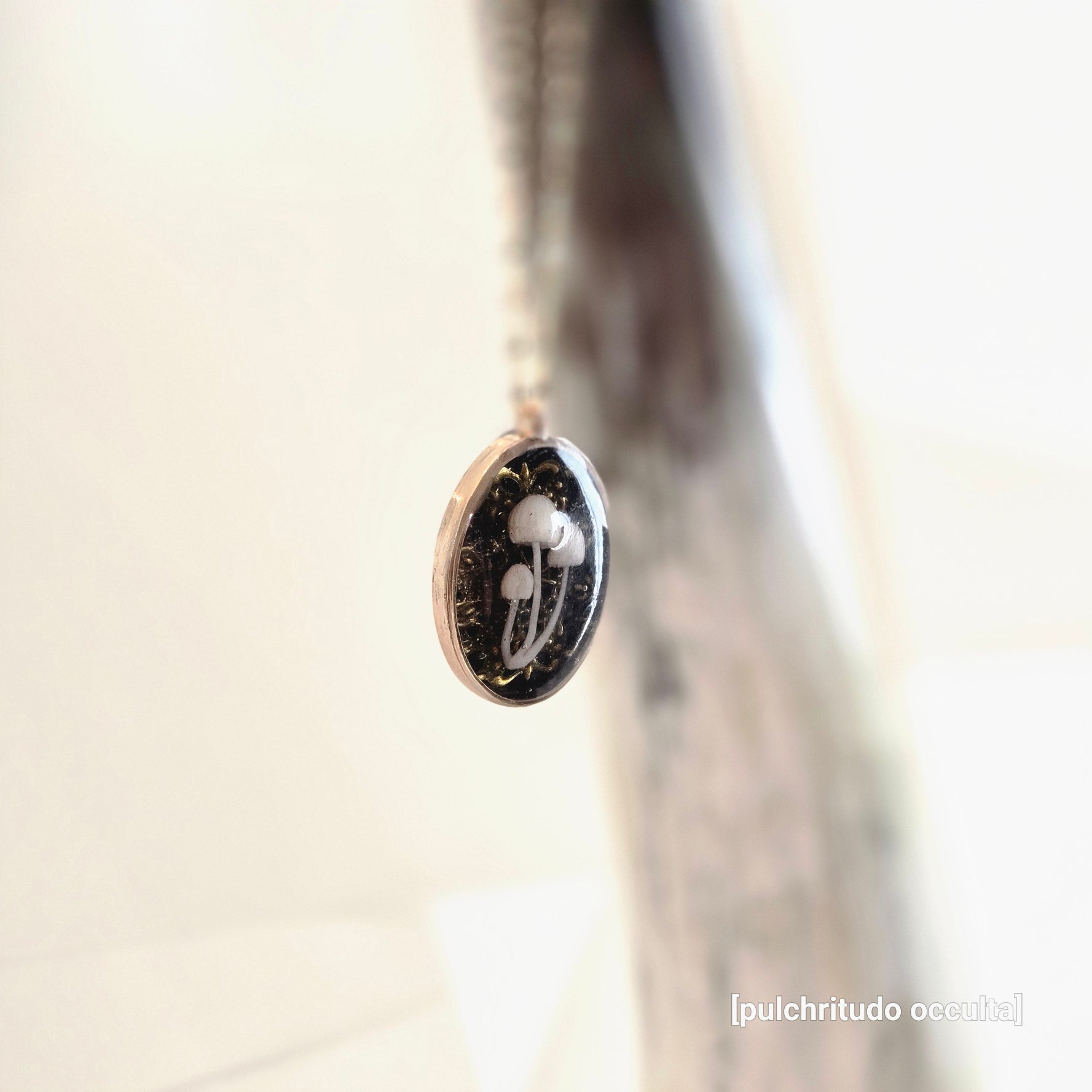 Jewelry pendant with a mushroom design on a blurred background