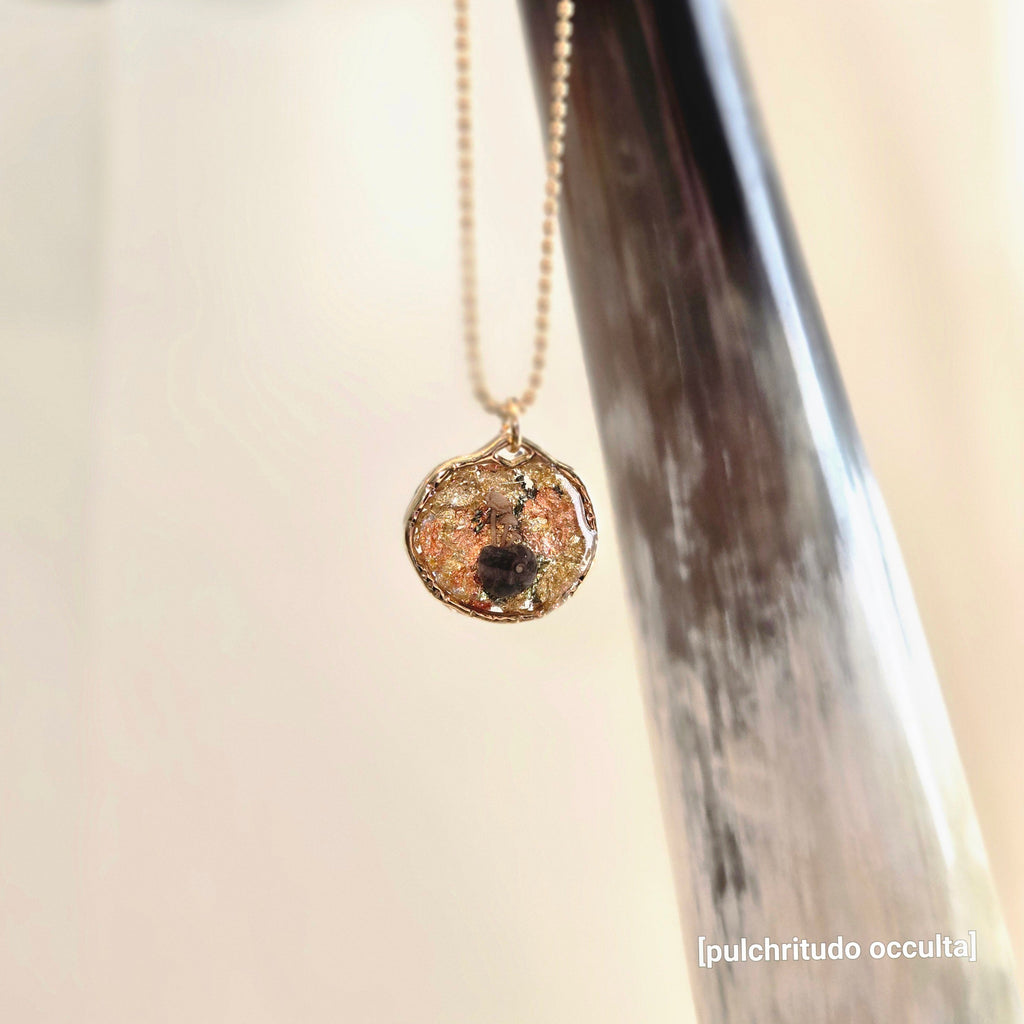 Necklace with a pendant hanging from a horn against a neutral background