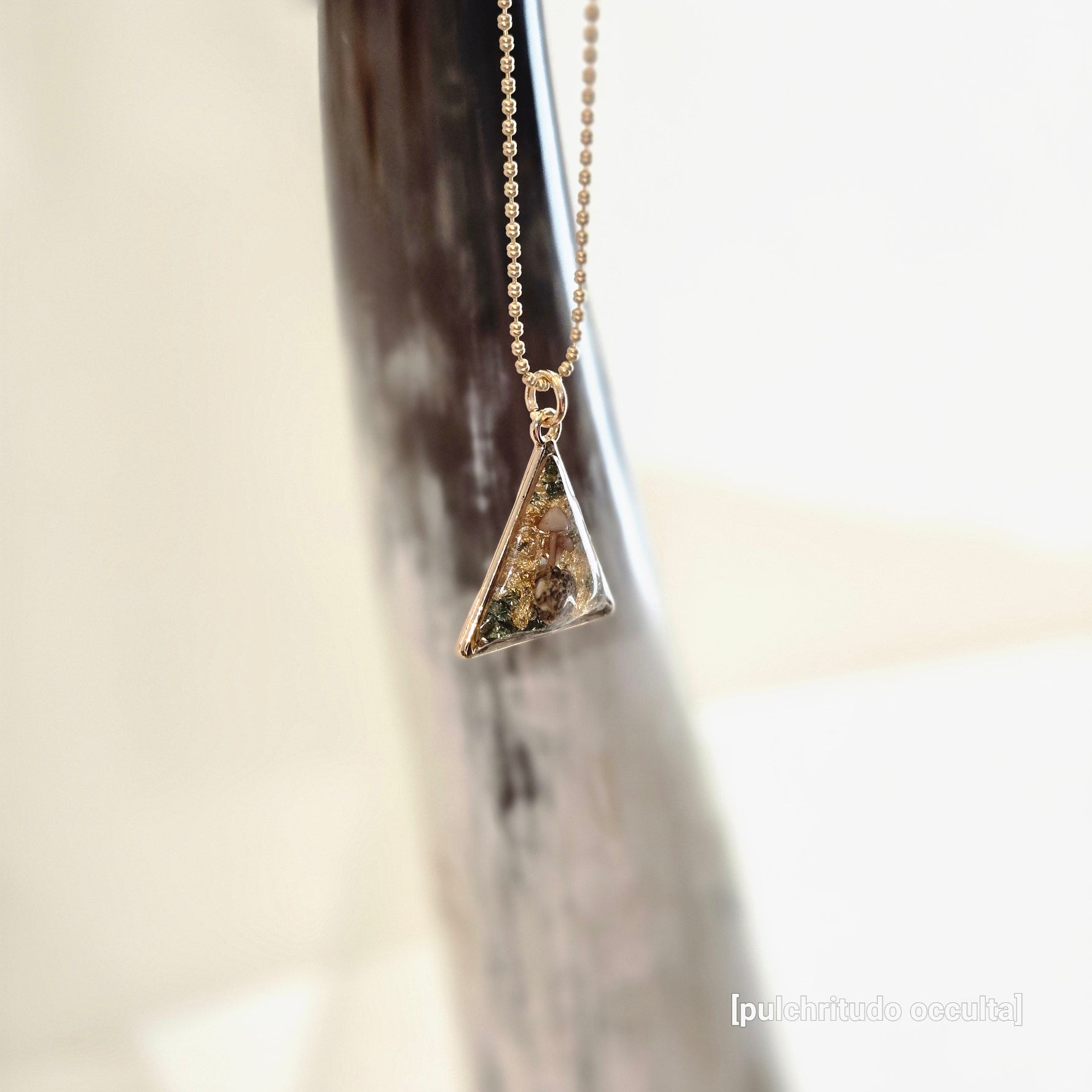 Gold necklace with a triangular pendant 