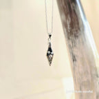 Silver necklace with a diamond shaped pendant featuring 2 small mushrooms