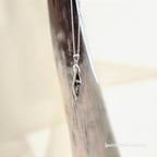 Silver necklace with a diamond shaped pendant featuring 2 small mushrooms