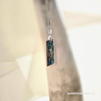 Silver necklace with a rectangular pendant with a metallic background