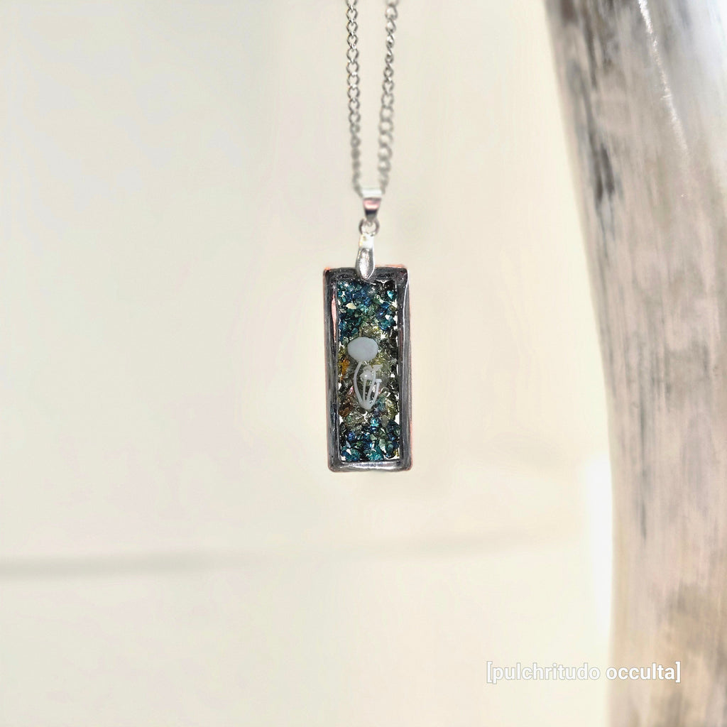 Necklace with a rectangular pendant featuring a mushroom design on a metallic background