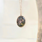 Necklace with a pendant featuring nature-themed design on a light background