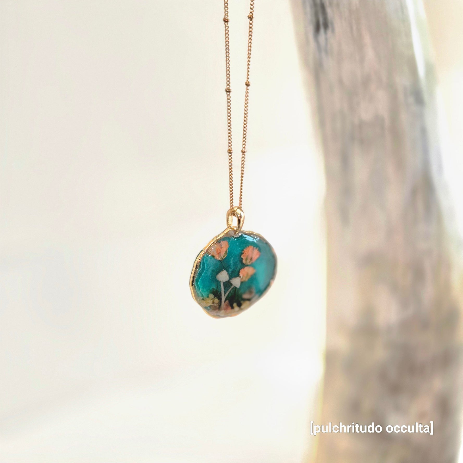 Necklace with a pendant featuring floral design on a blurred background