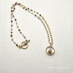 Necklace with a round pendant on a light background
