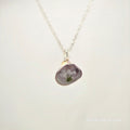 Necklace with a purple pendant on a white background