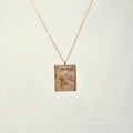 Necklace with a square pendant featuring floral design on a light background