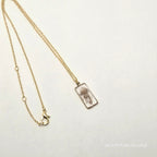 Gold chain necklace with a clasp on a light gray background