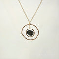 Necklace with a gold chain and pendant on a light beige background