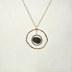 Necklace with a gold chain and pendant on a light beige background