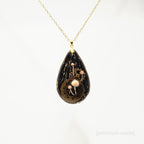Teardrop-shaped pendant with mechanical design on a white background