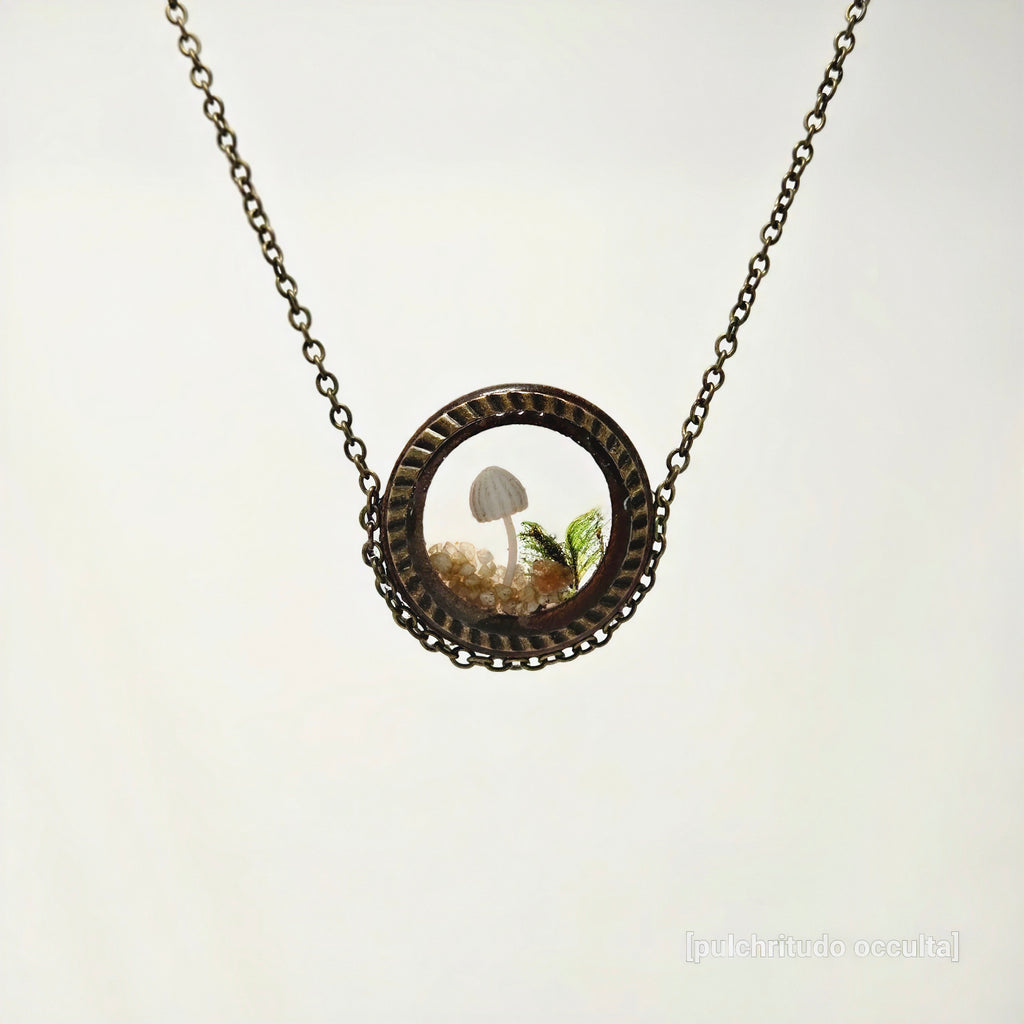 Necklace with a round pendant featuring a mushroom and fern on a white background
