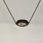 Necklace with a round pendant on a light gray background