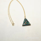 Necklace with a triangular pendant on a light gray background