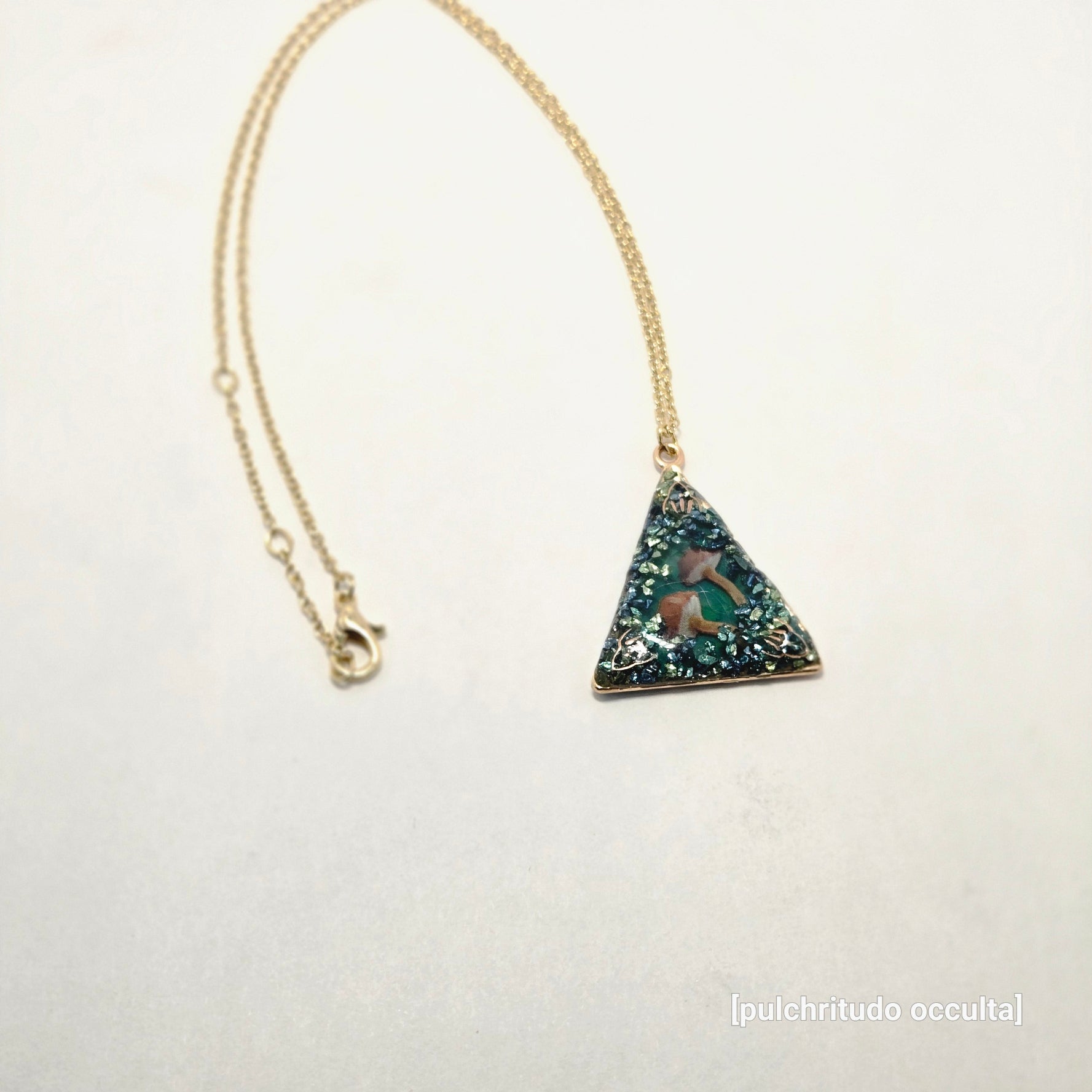 Necklace with a triangular pendant on a light gray background