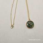 Necklace with a circular pendant on a light gray background