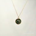 Necklace with a round pendant featuring a floral design on a light background