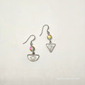 Pair of silver earrings with colorful beads on a light gray background