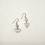 Pair of silver earrings with colorful beads on a light gray background