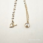 necklace on a light gray background with 'puichritud oculta' branding.