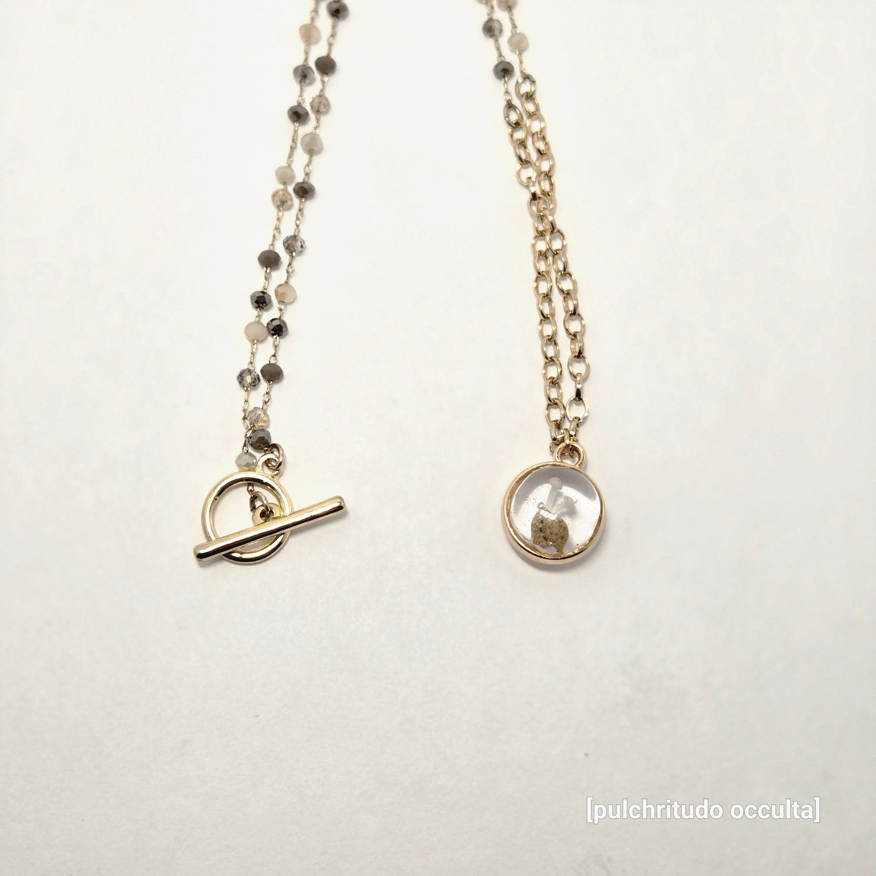 necklace on a light gray background with 'puichritud oculta' branding.
