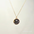Necklace with a round pendant on a light beige background