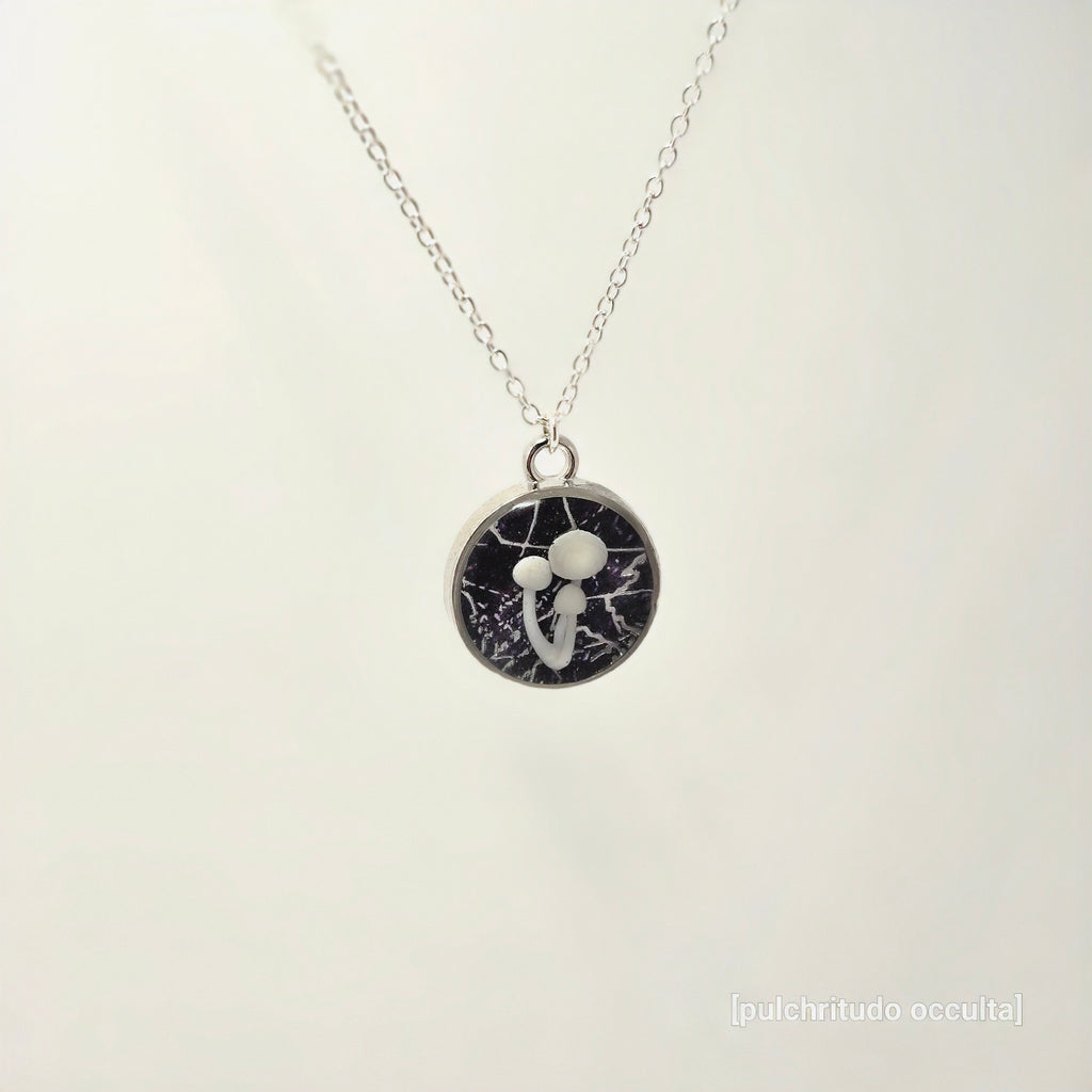 Necklace with a round pendant featuring a black and white design on a light gray background.