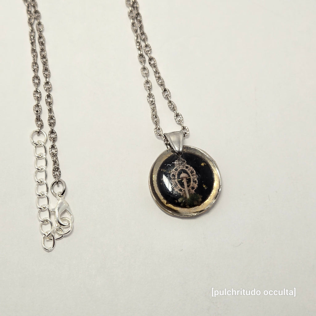 Silver necklace with a round pendant on a light gray background