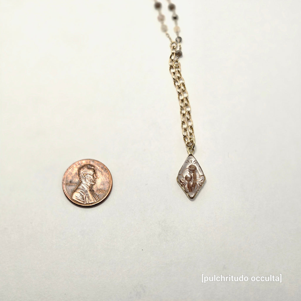 Small gold pendant with a mushroom design on a white background
