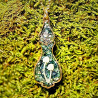 Necklace with a pendant on a green moss background