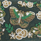 Decorative fabric with embroidered flowers and butterflies on a dark background