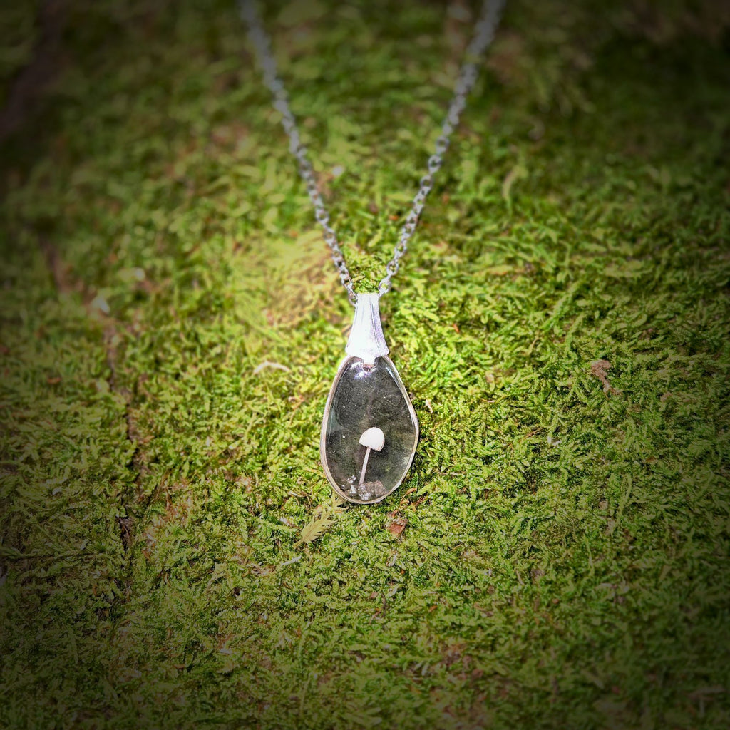 Necklace with a pendant on a mossy surface