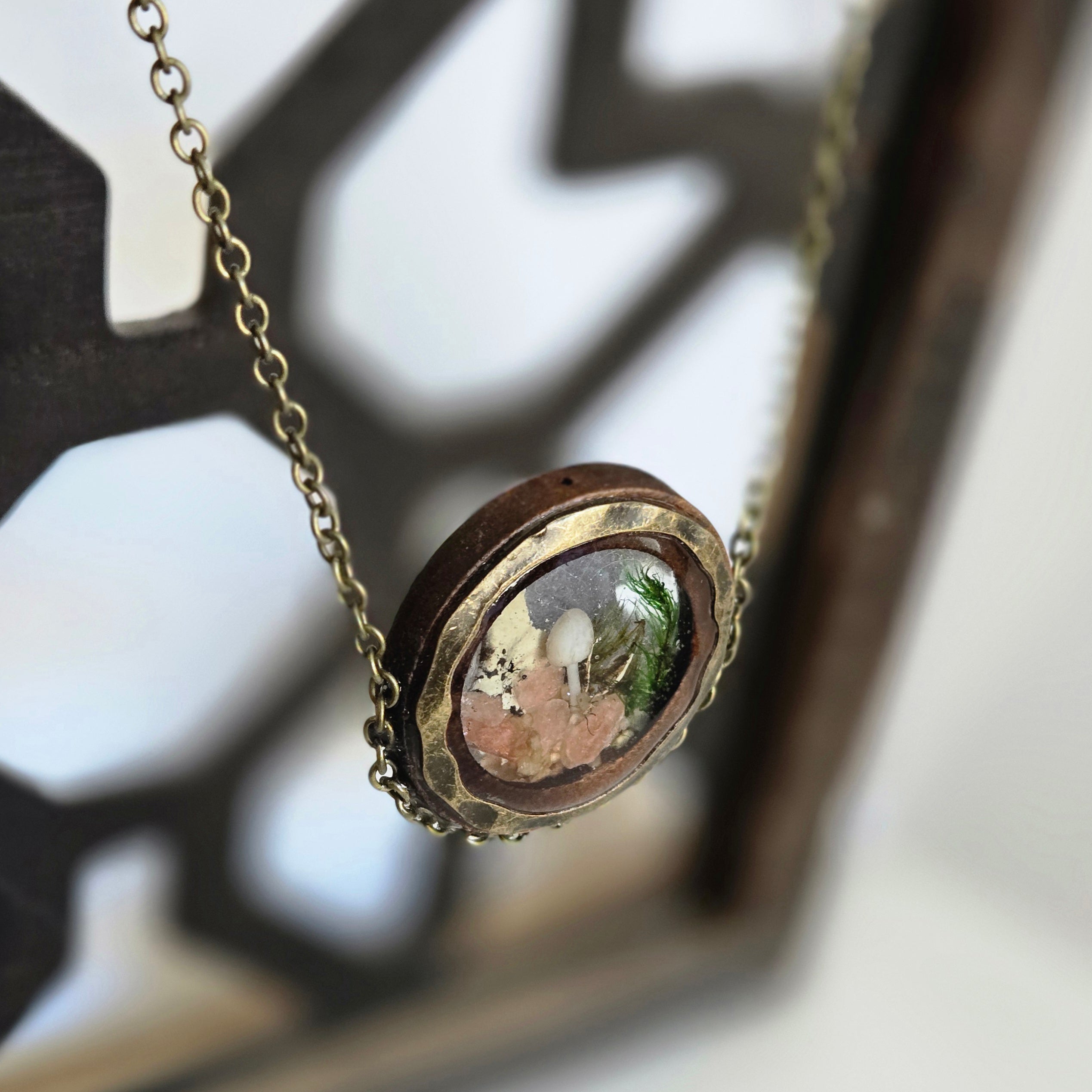Necklace with a round pendant featuring a miniature landscape.