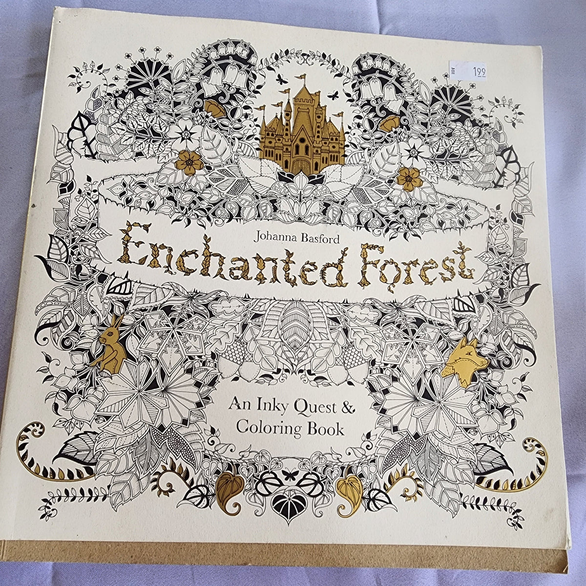Coloring book titled 'Enchanted Forest' by Johanna Basford on a light purple background